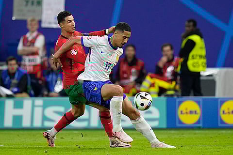 Cristiano Ronaldo and William Saliba struggle for the ball